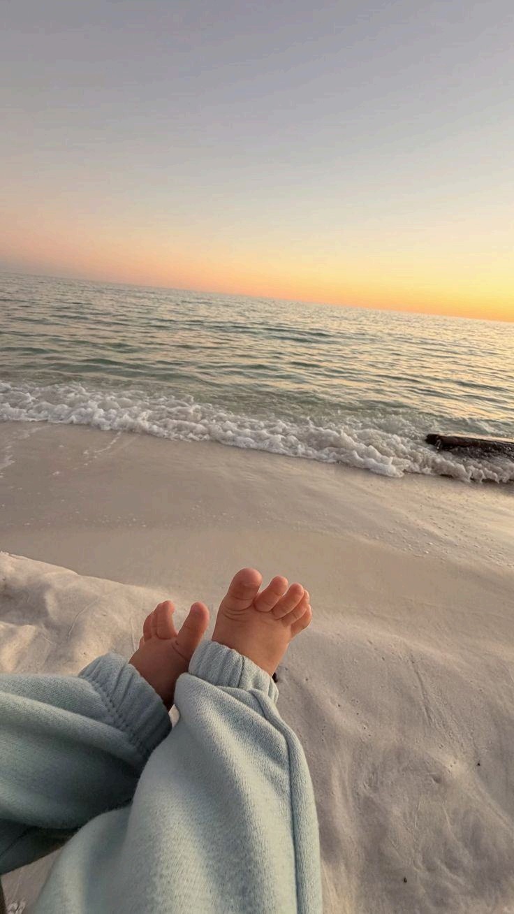 Baby feet beside the ocean at golden hour